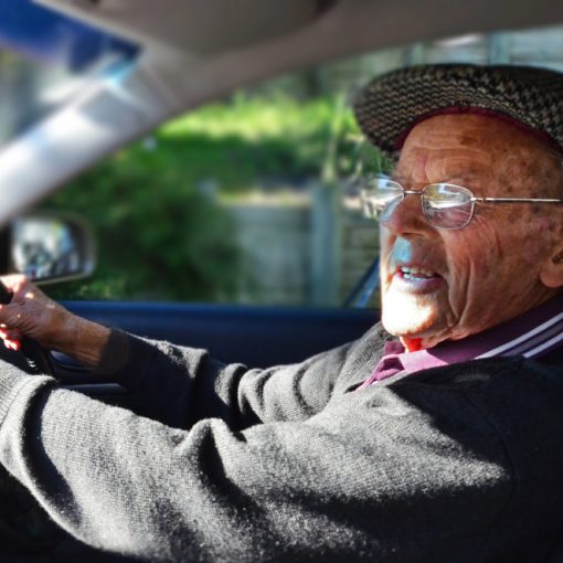 Oude man achter het stuur van een auto