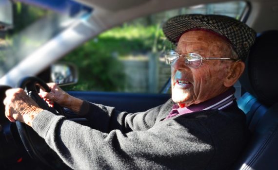 Oude man achter het stuur van een auto